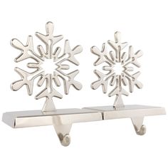 two silver snowflakes are sitting on hooks