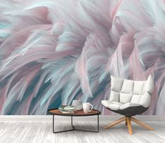 a chair and table in front of a wall with pink feathers on it, next to a coffee table