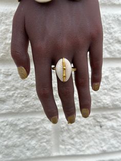 This artisanal Cowry shell and Brass adjustable Ring adds a touch of bohemian charm to any outfit. Handmade with precision and attention to detail, each ring offers a unique and stylish look. A perfect addition to your jewelry collection. sold as 1 per price Bohemian Brass Jewelry For Beach, Bohemian Brass Jewelry For The Beach, Artisan Cowrie Shell Jewelry, Artisan Adjustable Cowrie Shell Jewelry, Gold Shell Rings For Beach, Artisan Shell Jewelry With Adjustable Fit, Shell-shaped Brass Jewelry For The Beach, Artisan Adjustable Shell Jewelry, White Beach Ring Jewelry