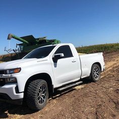 a white truck parked on top of a dirt field