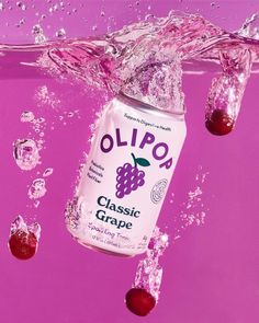 a can of olipo grape soda floating in the water with splashes around it