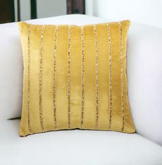 a yellow pillow sitting on top of a white couch