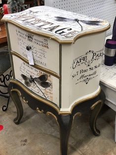 a white and black chest of drawers with writing on the top, in a store