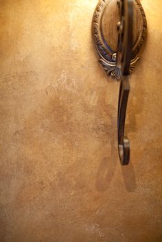 an old fashioned phone is hanging on the wall next to a door handle and mirror