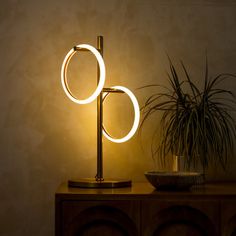 a lamp that is sitting on top of a table next to a potted plant