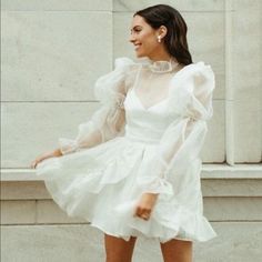 a woman wearing a white dress and high heels