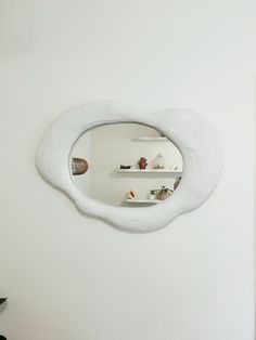 a mirror that is on the side of a wall with shelves in front of it