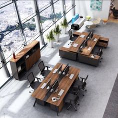 an office area with desks and chairs in front of large windows overlooking the city