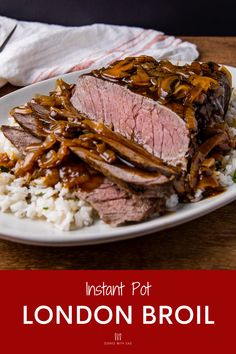 a white plate topped with meat and rice on top of a wooden table next to a fork