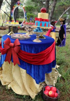 a blue table topped with a cake next to apples