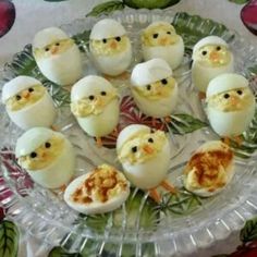 there are many deviled eggs with chicken heads in them on a glass platter