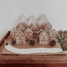 a cake that is sitting on top of a wooden table next to some pine cones