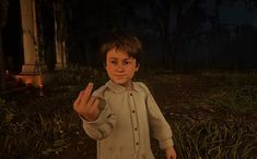 a young boy standing in the middle of a forest at night with his hand up