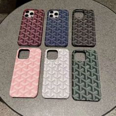 four different cases sitting on top of a table next to each other, one is pink and the other is blue