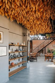 the interior of a restaurant with open shelves and wooden beams hanging from the ceiling above