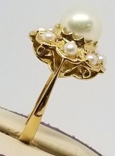 "We do not check prongs for wear or stones for looseness. All items are sold as is-noting that we are a resale shop so everything here had a previous owner! We will include flaws in the description when noted. This is one of the reasons our items are more affordable than new at a jewelry store. Vintage 18K Yellow Gold Pearl Ring, Size 6. Stamped K18 inside band. Main Pearl is 7.2mm others are 2.5mm. Weighs 2.1 dwt. Please stop in often as we will be adding additional vintage fine jewelry beautie Classic Yellow Gold Rings With High Luster, 14k Gold High Luster Wedding Rings, Classic High Luster Yellow Gold Rings, Classic Gold Rings With High Luster, 14k Gold Rings With Aaa Quality For Anniversary, Aaa Quality 14k Gold Rings For Anniversary, Heirloom High Luster Rings For Anniversary, High Quality 14k Gold Rings For Anniversary, Vintage High Quality Jewelry For Formal Occasions