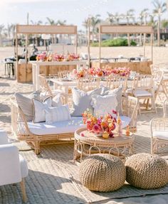 tables and chairs set up on the beach for an outdoor wedding reception with flowers in vases