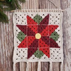 a crocheted christmas ornament hanging on a wooden wall with ornaments around it