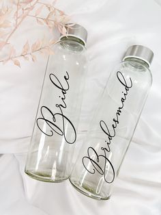 two personalized water bottles sitting on top of a bed