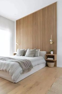 a large bed sitting in the middle of a bedroom next to a wooden headboard