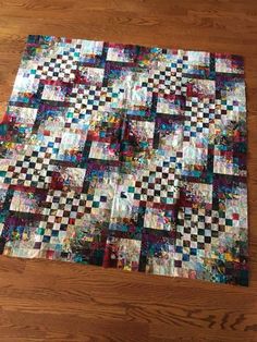 a patchwork quilt sitting on top of a wooden floor