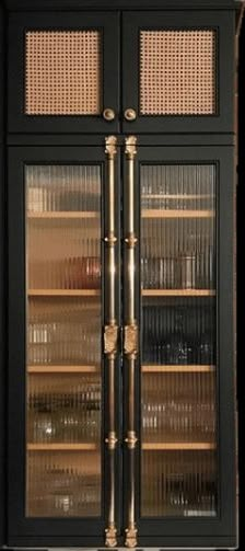 a tall black cabinet with glass doors and gold trimmings on the bottom shelf