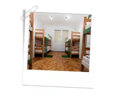 there are many bunk beds in this room with wood flooring and green ladders