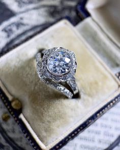 a diamond ring sitting on top of a velvet box