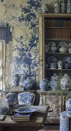 a room filled with lots of blue and white vases sitting on top of a table