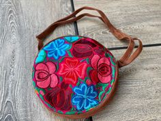 "Beautiful Suede floral Embroidered round bag. Dimensions: Bag- 11\" Diameter Strap- 44\" 🧵Made in Chiapas, Mexico. 🧺Care Instructions: Spot clean only. 📲Feel free to contact us with any questions you may have!  🛍More colors and styles in our Etsy shop: https://www.etsy.com/shop/mexitlii 🇲🇽Hablamos Español." Brown Round Bag For Daily Use, Round Brown Shoulder Bag For Travel, Brown Round Shoulder Bag For Travel, Bohemian Round Bag For Everyday Use, Handmade Round Bag For Everyday Use, Spring Red Embroidered Bag, Mexican Purse, Round Crossbody Bag, Suede Handbags