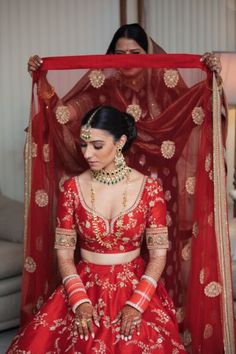 a woman in a red and gold bridal outfit