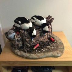 two black and white birds sitting on top of a bag filled with stuff next to a wall