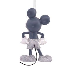 a mickey mouse ornament hanging from a string with glitter on it's feet