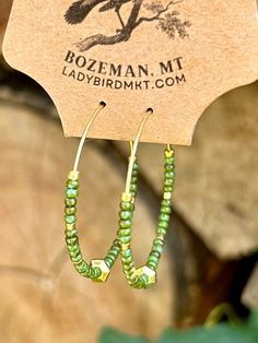 Introducing our vibrant Boho Seed Bead Hoop Earrings! These are the perfect blend of bohemian charm and contemporary style, featuring a delicate gold-colored hoop adorned with hunter-green earth-toned Czech glass seed beads with an eye-catching gold centerpiece. The beads, available in a kaleidoscope of hues, create an eye-catching mosaic.Our Boho Seed Bead Hoop Earrings are also incredibly lightweight, ensuring optimal comfort. Whether you're heading to a music festival, a beach getaway, or simply want to add a pop of color to your everyday ensemble, these earrings are the perfect choice. They effortlessly elevate any outfit, from casual boho-chic looks to more elegant and sophisticated styles. Gold Hoop Earrings With Tiny Beads For Summer, Green Hoop Earrings With Colorful Beads, Bohemian Beaded Hoop Earrings For Everyday, Everyday Bohemian Beaded Hoop Earrings, Green Small Hoop Beaded Earrings With Tiny Beads, Bohemian Hoop Earrings With Gold Beads Adjustable, Green Small Hoop Earrings With Tiny Beads, Bohemian Gold Beaded Hoop Earrings, Green Hoop Earrings For Festival