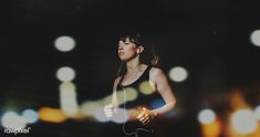 a woman is running in the dark with headphones around her neck and ear phones hanging from her ears