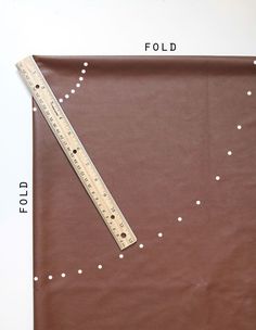 a ruler is placed on top of a brown piece of paper that has white dots