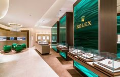 a jewelry store with green chairs and glass displays on the wall, along with other jewelry items