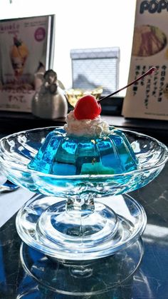 a glass dish with ice cream and a cherry on top