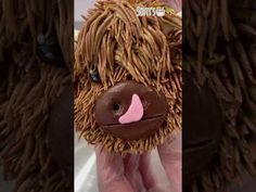 a close up of a stuffed animal made out of brown hair and pink tongues