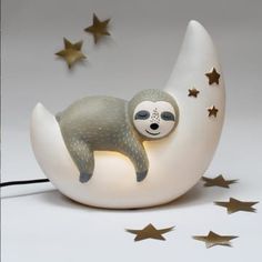 a lamp with a slotty sleeping on top of the moon and stars around it