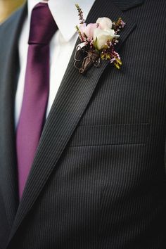 a man in a suit and tie with a boutonniere on his lapel