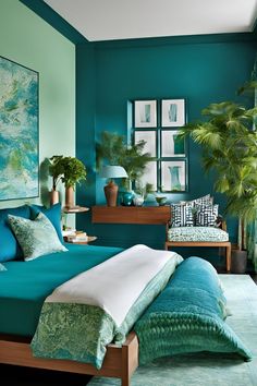 a bed room with a neatly made bed next to a green wall and two potted plants