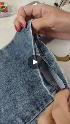 someone is sewing something on a piece of denim