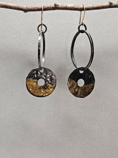 I usually incorporate stones in my work, but sometimes sterling silver accented with rich high karat gold is just right. I like the fact that bimetals go with everything and can work for an easy everyday earring. These earrings are a modified hoop. They are a circle hoop with a wider flat circle dangle. The larger circle is approximately 1 inch in diameter. Both circles are hammered with organic textures, lightly oxidized and then polished for a bright finish. The oxidation adds contrast to the texture and makes the gold pop. The flat circle dangle has been accented with gold utilizing the ancient Korean method of Kuem Boo.  They hang from custom-made gold filled ear wires and a soldered jump ring. The earrings hang approximately 2 1/2 inches from the top of the ear wire to the bottom of t Elegant Gold Hoop Earrings With Oxidized Finish, Hammered Oval Earrings For Anniversary, Oval Hammered Earrings For Anniversary, Artisan Hammered Yellow Gold Earrings, Artisan Yellow Gold Hammered Earrings, Gold Fusion Earrings With Oxidized Finish, Unique Oval Yellow Gold Earrings, Artisan Gold Oval Earrings, Hammered Round Fusion Jewelry