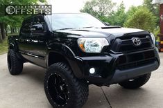 a black truck is parked in the driveway