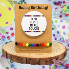 a happy birthday card with the words love comes in all colors on top of it