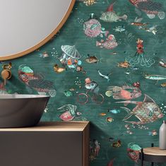 a bathroom with green wallpaper and colorful fish on the wall next to a sink