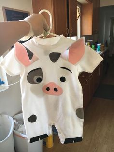 a person holding up a white shirt with a cow face on it's chest