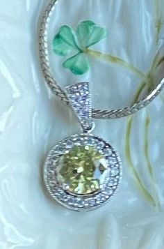 "This is a vintage silver necklace with classic light green round Peridot center rhinestone with small diamond like rhinestones surrounding it.  This is a beautiful piece of jewelry for an upcoming wedding or holiday events. It would accent any colors for causal or dressy style. Bring this necklace to your happy place! Excellent vintage condition. Silver toned necklace length approximately 9\" long. The bright pendant measures 1.25\"x 1.25\". All stones present. Lots of sparkling! Thanks for sto Dazzling Green Diamond Necklace For Anniversary, Vintage Round Diamond Necklace Gift, Wedding Silver Diamond Necklace With Birthstone, Dazzling Round Rhinestone Necklace With Diamond Accents, Round Cubic Zirconia Costume Jewelry Necklace, Dazzling Green Diamond Necklace Gift, Round Cubic Zirconia Costume Necklace, Dazzling Green Diamond Necklace For Gift, Yellow Round Necklaces With Diamond Accents