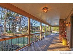 a porch with wooden floors and railings next to a fire hydrant on the other side